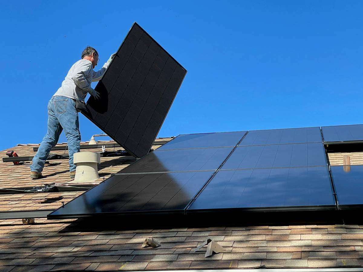 Engineer reviewing a solar panel system plan on blueprint with roof measurements and shading analysis